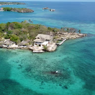 Island with houses surrounded by clear blue water