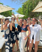 Group of women celebrating with champagne by a poolside