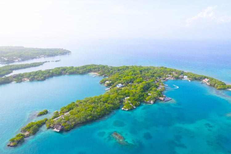 Island with lush greenery surrounded by clear blue water